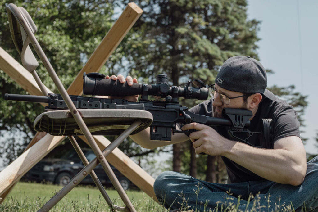 Tirador con rifle en competición, destacando seguridad y legislación.